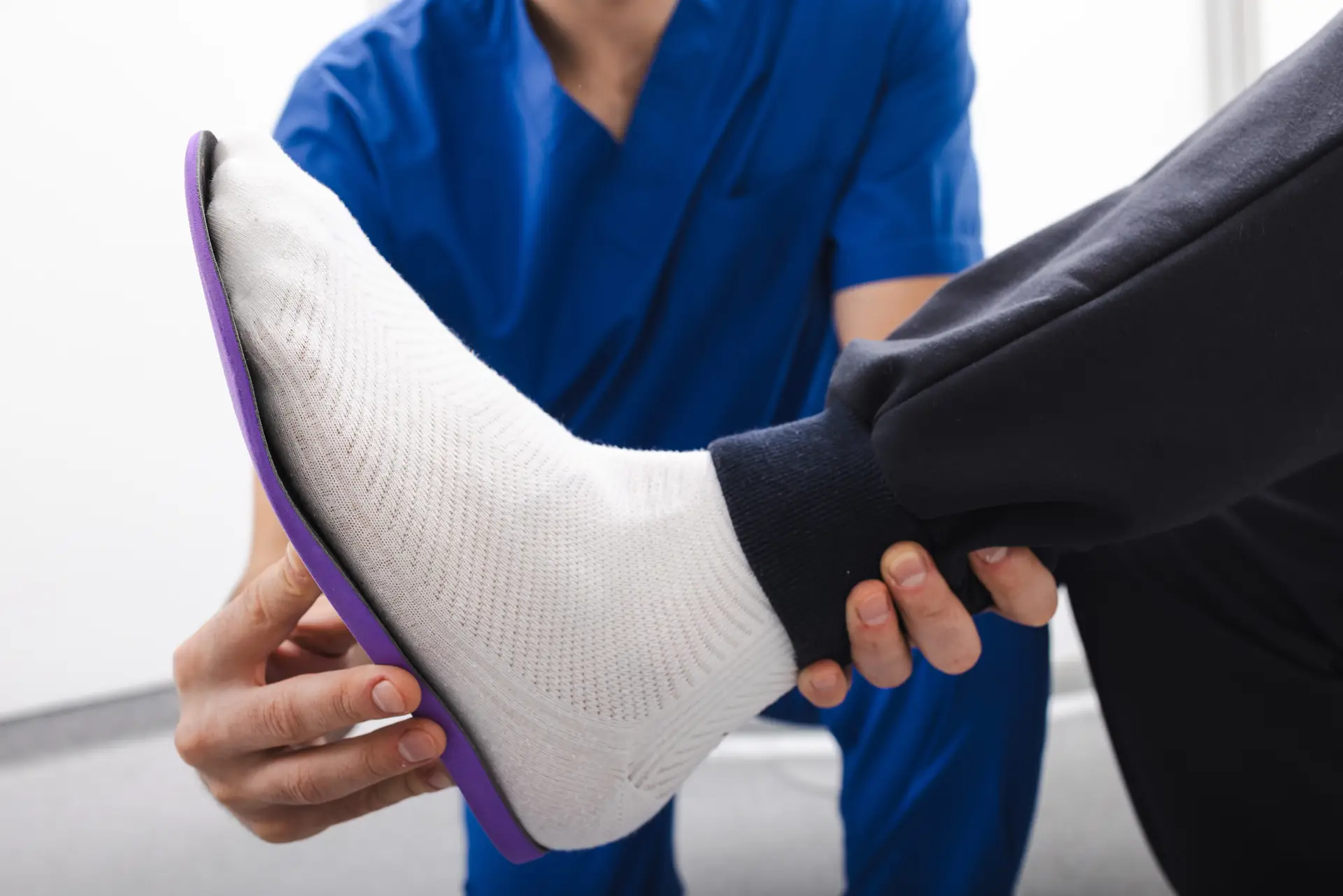Orthopedist fitting individual orthopedic insole for patient foot
