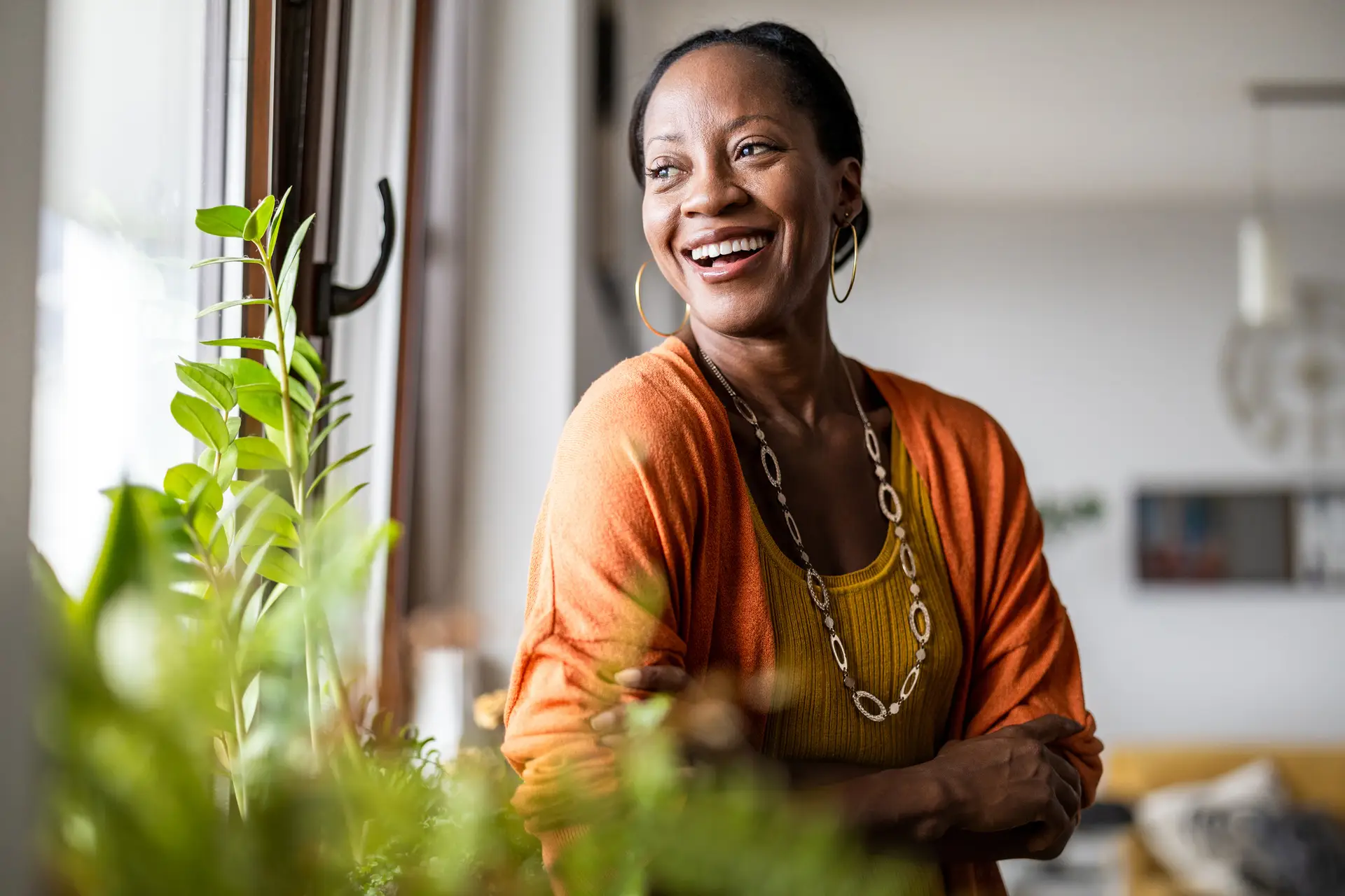 Portrait of a smiling woman standing in her apartment