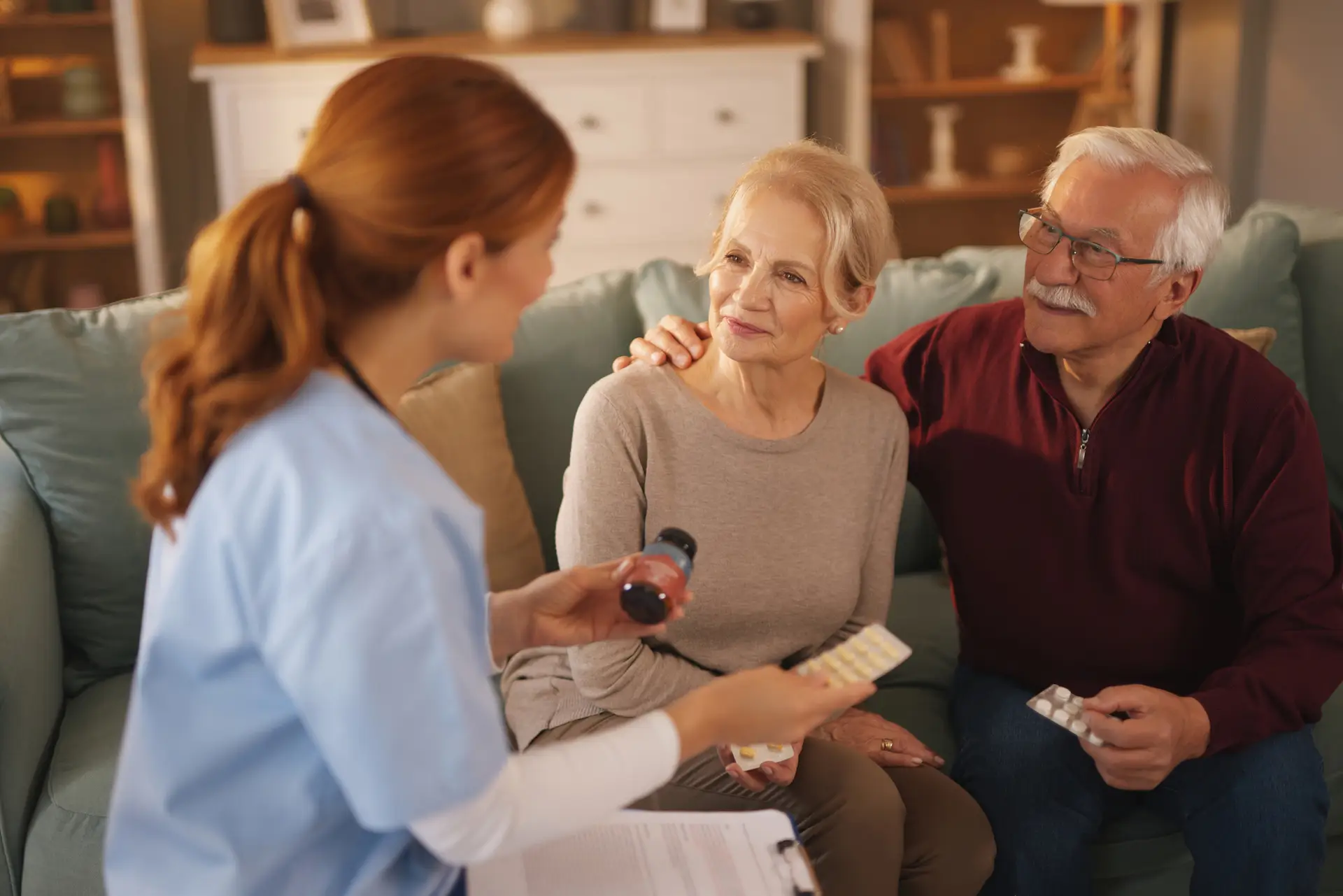Nurse explaining medicine treatment to senior couple at home