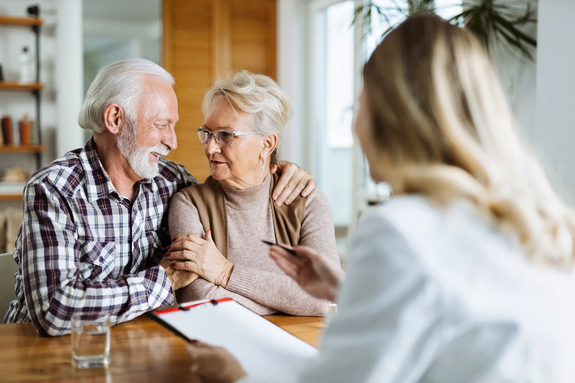 Female doctor talking with senior couple during her home visit