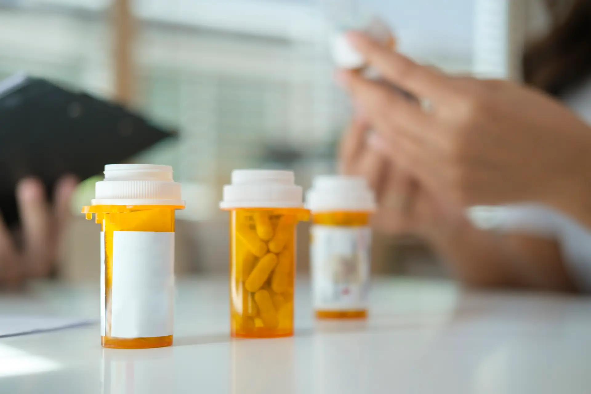 Prescription pill bottle spilling pills on to surface isolated on a white background.