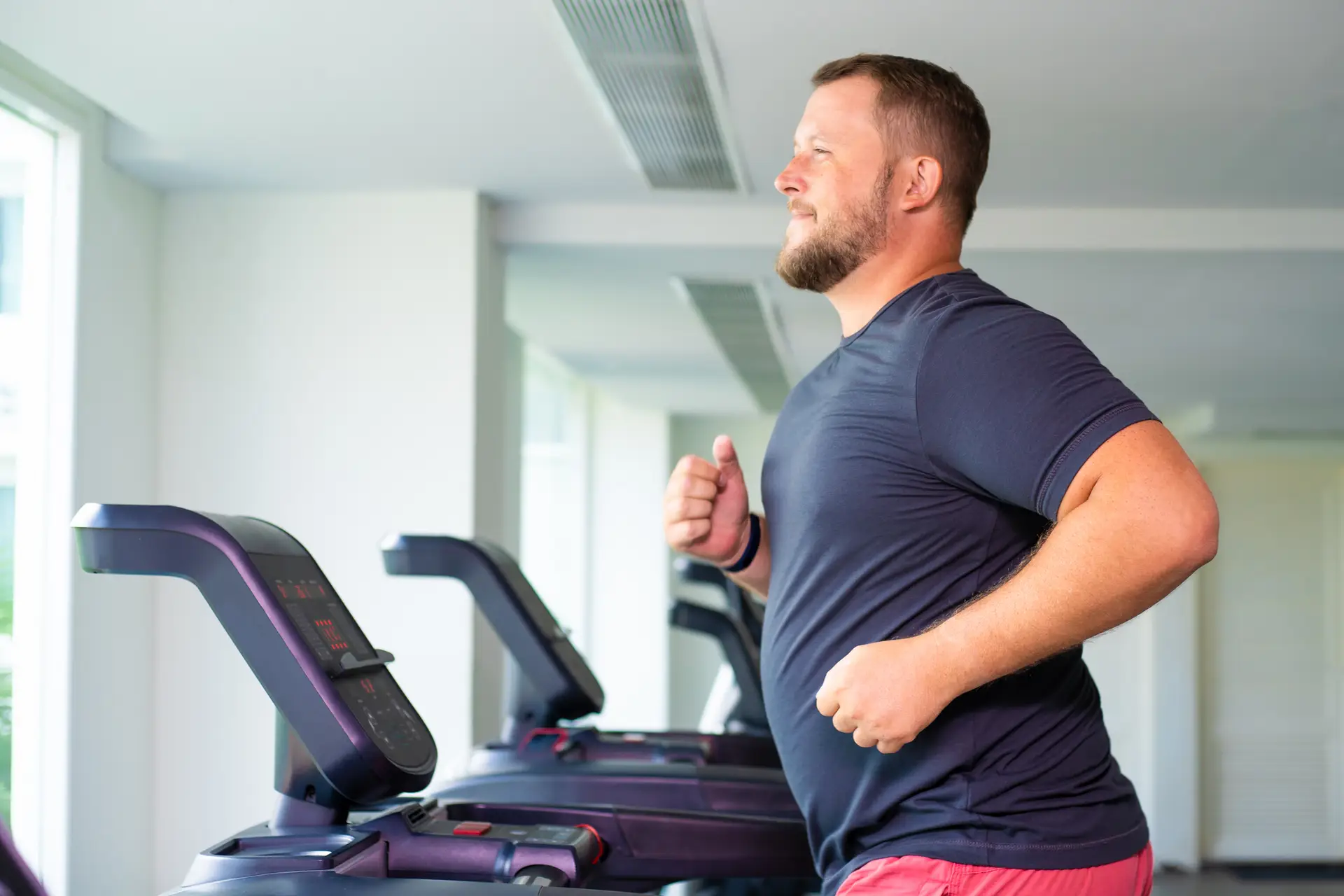 male runs on a treadmill in a gym